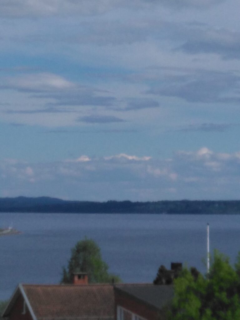 Utsikt över Storsjön en majkväll med moln och gröna träd